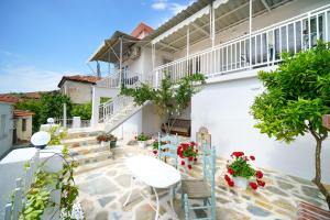 a patio of a house with chairs and flowers at Marika's House in Kallirakhi