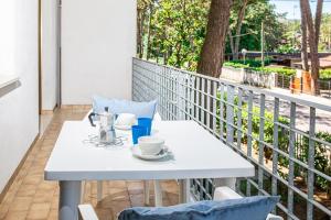 Appartamenti Valentina في بيبيوني: طاولة بيضاء مع أكواب وصحون على شرفة