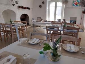 Masseria San Martino في بولينيانو آ ماري: غرفة طعام بطاولات بيضاء وكراسي خشبية