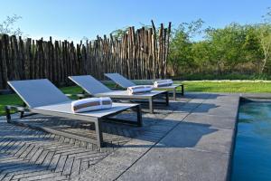 3 sedie a sdraio sedute accanto alla piscina di The Orpen Kruger a Welverdiend