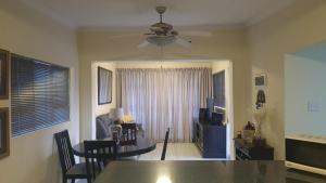a living room with a table and a ceiling fan at 20 Almond Rd in Kingsburgh