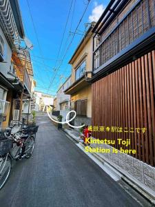 京都東雲夏~距京都站900米步行12分、近鄰東寺站150米步行2分，三室一廳兩衛浴二層獨棟~最多可住9人的一条街道,旁边是建筑物和自行车