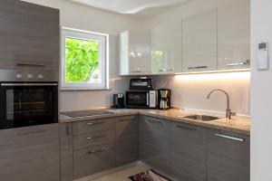 a kitchen with stainless steel appliances and a window at House Zrile with jacuzzi in Baška