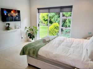 1 dormitorio con cama y ventana grande en Colourful Horizons, en Germiston