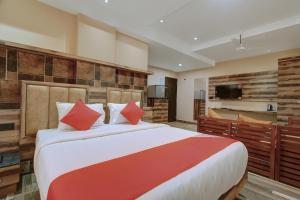 a bedroom with a large bed with red pillows at Laxman Residency in Kulurkudrū