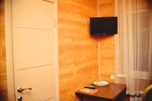 Habitación con puerta y TV en la pared en Sapar Budget Hotel, en Shymkent 3 fotos más