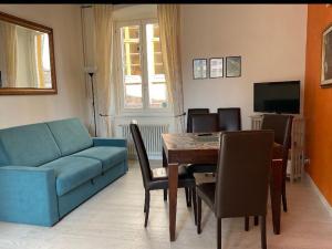 salon ze stołem i niebieską kanapą w obiekcie RUBY HOME Città Alta w Bergamo