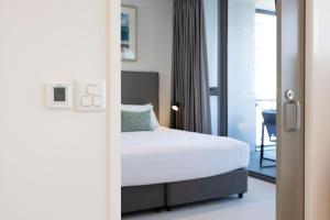 a bedroom with a bed and a glass door at ULTIQA Signature at Broadbeach in Gold Coast