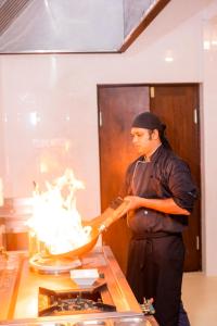 um homem a preparar comida numa cozinha de restaurante em Somerset Mirissa Blue em Mirissa