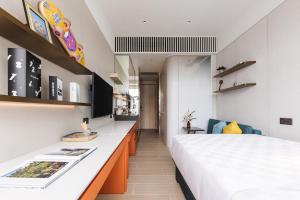 una camera d'albergo con letto e scrivania di TOWNPLACE WEST KOWLOON a Hong Kong