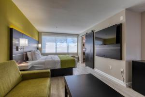 a hotel room with a bed and a couch and a tv at Hotel Weston in Marietta