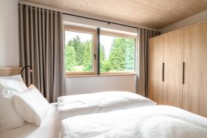 a bedroom with two white beds and a window at Freiheit in Bolsterlang