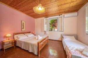 ein Schlafzimmer mit zwei Betten und einem Fenster in der Unterkunft Artemis House in Karavomylos
