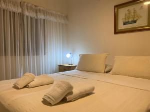 a bedroom with a large bed with two pillows on it at De La Plaza Hotel in Villa Gesell