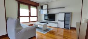 a living room with a tv and a couch and a chair at Bermeo Kaia in Bermeo