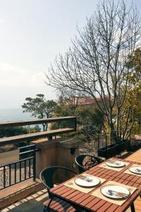 een houten tafel op een terras met uitzicht op de oceaan bij Cicer Cliff Sea View Villa in Dali