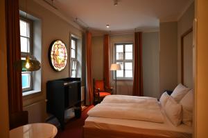 a hotel room with a bed and a television at Pension Alter Bischofshof in Naumburg