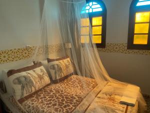 a bedroom with a bed with a mosquito net at Riad Salt River in Martil