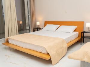 a bedroom with a large bed with white sheets and pillows at ALLAGIANNIS GROUP APARTMENTS in Markopoulo