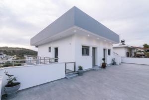 a white house with a large roof at Lychnos apartments in Kamilari