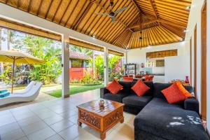 uma sala de estar com um sofá e uma mesa em Romantica Villa Ubud em Ubud