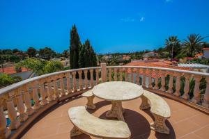 d'une table et de chaises en bois sur un balcon. dans l'établissement Cometa-86 - villa with private pool close to the beach in Calpe, à Empedrola