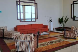salon z pomarańczową kanapą i krzesłami w obiekcie Marriott Venezuela Hotel Playa Grande w mieście Playa Grande