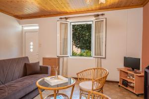 ein Wohnzimmer mit einer Couch und einem Fenster in der Unterkunft Artemis House in Karavomylos