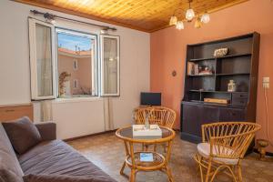 ein Wohnzimmer mit Sofa, Tisch und Stühlen in der Unterkunft Artemis House in Karavomylos
