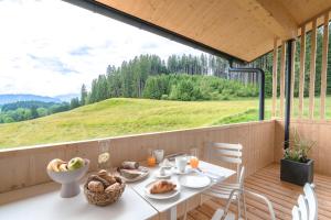 a table with food on a balcony with a view of a field at Freiheit in Bolsterlang