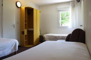 Cette chambre comprend 2 lits et une fenêtre. dans l'établissement Hôtel Lémand Lyon Est - Villefontaine, à Villefontaine