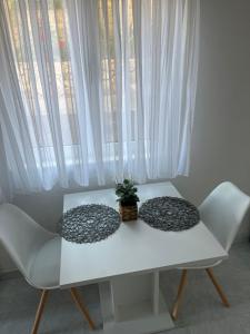two pillows sitting on a white table in front of a window at Apartments Despotović in Vis