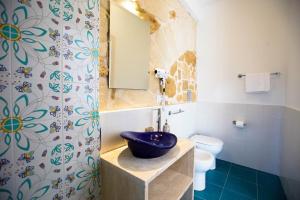 bagno con lavandino blu e servizi igienici di Sciabika Home - Edificio Eolie a Castellammare del Golfo
