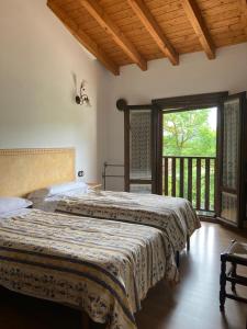 two beds in a bedroom with a balcony at Apartamentos Rurales Casa Lafuente in Luquiano