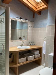 a bathroom with a sink and a mirror at Apartamentos Rurales Casa Lafuente in Luquiano