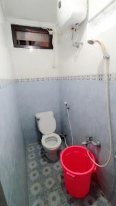 bagno con secchio rosso e servizi igienici di Griya Soragan a Ngabean
