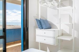 una stanza con mobili bianchi e vista sulla spiaggia di Columbus Vista Mare a Bibione