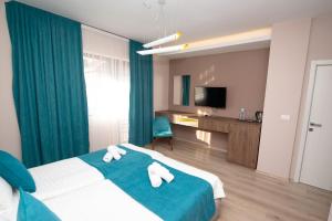 Habitación de hotel con cama y TV en ZARO Apartments, en Bitola
