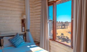 een slaapkamer met een bed en een groot raam bij Salt Lick Safari Lodge in Tsavo