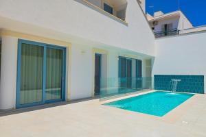 una piscina en medio de una casa en Perle Marine Suite Apartments, en Castro di Lecce