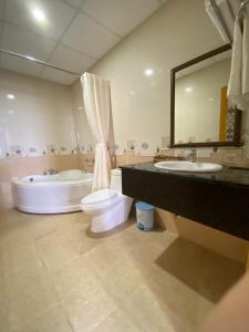 a bathroom with a tub and a toilet and a sink at Linh Phuong 8 Hotel in Can Tho