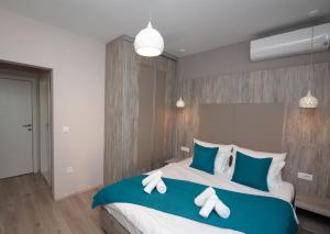 1 dormitorio con 1 cama grande con almohadas azules y blancas en ZARO Apartments, en Bitola
