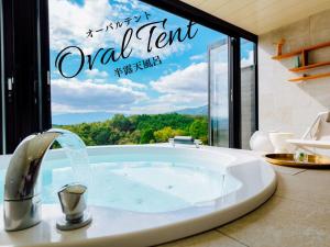 a bathroom with a tub with a sign that reads oral term at Yufuin Glamping COMOREBI in Yufuin