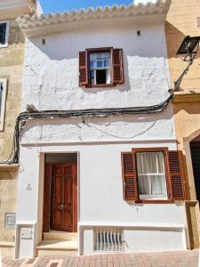 een wit gebouw met twee ramen en een deur bij Canostra Menorca Alaior in Alaior