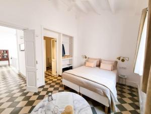 een slaapkamer met een bed en een geruite vloer bij Canostra Menorca Alaior in Alaior