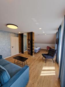 ユルバルカスにあるEditos apartamentaiのリビングルーム(青いソファ、テーブル付)