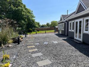 a house with a gravel driveway next to a house at Milltown House Dingle in Dingle