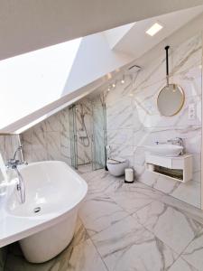 a bathroom with a white tub and a sink at Editos apartamentai in Jurbarkas