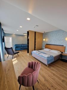 ユルバルカスにあるEditos apartamentaiのベッドルーム1室(ベッド1台、椅子、テーブル付)
