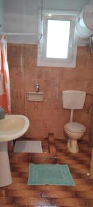 ein Badezimmer mit Toilette und Waschbecken und einem Fenster in der Unterkunft Artemis House in Karavomylos + 36 Fotos